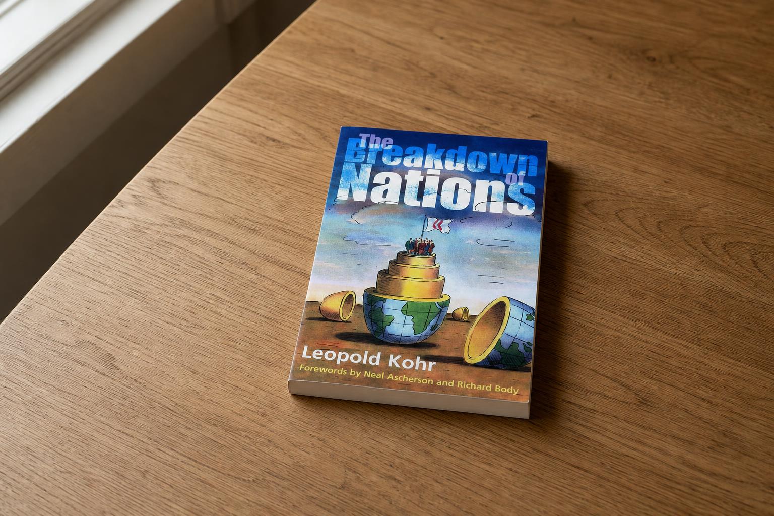 Leopold Kohr's The Breakdown of Nations lying on a quiet wooden table in soft window light.