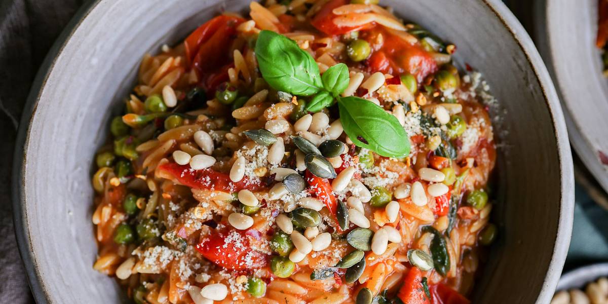 Cremige Tomaten-Orzo mit gerösteten Pinienkernen.