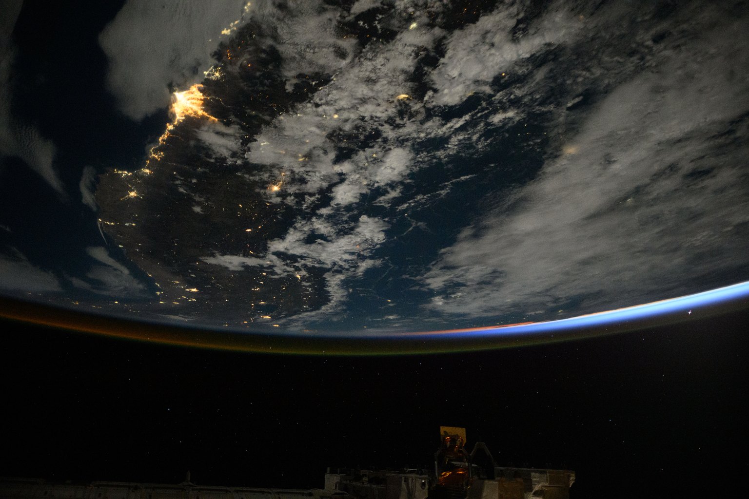 An astronaut photograph from the International Space Station of the Peruvian coast at night, the lights of Lima and Callao gathered along the shoreline against the dark Pacific.