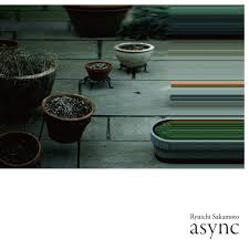Cover of Ryuichi Sakamoto's async: a pale, abstract, high-contrast image with soft grey-white textures and minimal black typography.
